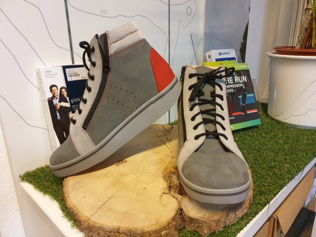 Sneaker mit seitlichem Reißverschluss und schwarz-weißen Schnürsenkeln, moderne Herren- oder Damenschuhe, bequeme Alltagsschuhe, stylisch und bequem.