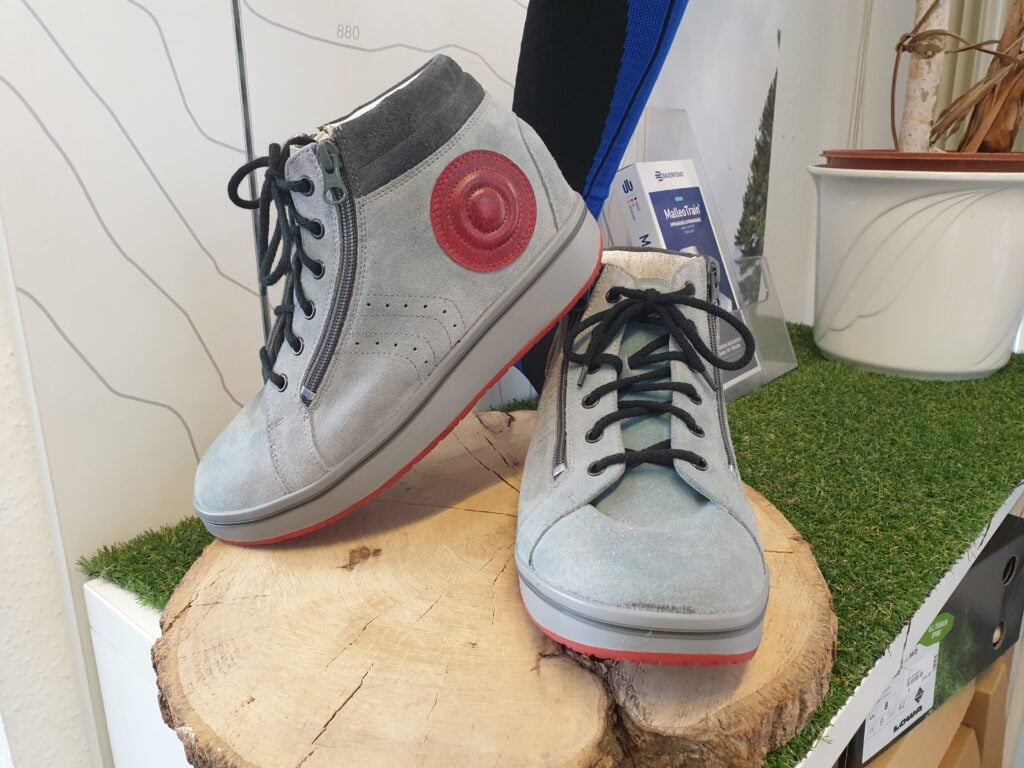 Sneaker, modische Schuhe aus Veloursleder mit seitlichem Reißverschluss und Schnürung, trendy Casual-Look, ideal für Alltag und Freizeit, auf Holzblock mit künstlichem Gras, Präsentation bei Schritt Vital.